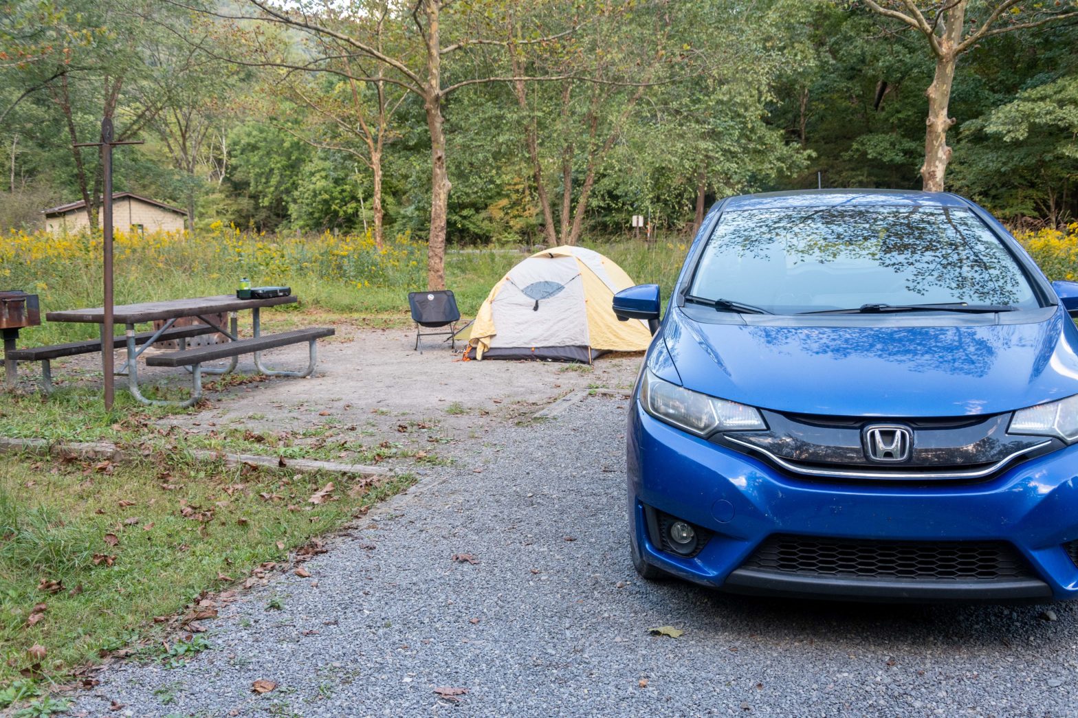 Blue car in front of a tent at a campsite